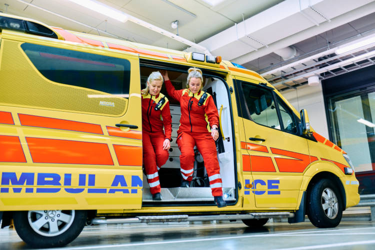 Kaksi ensihoitajaa hyppäämässä ambulanssista.